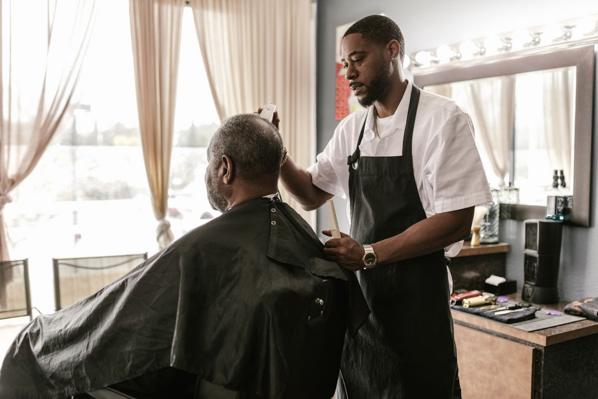 Barbero cortando el cabello de un cliente