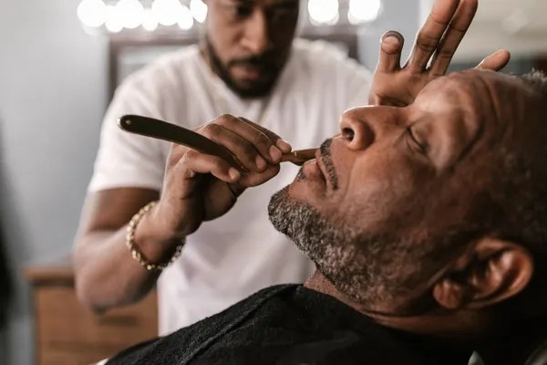 Barbero afeitando con navaja clásica