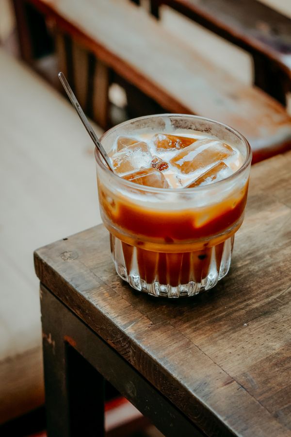 Vaso de iced coffee sobre mesa de madera