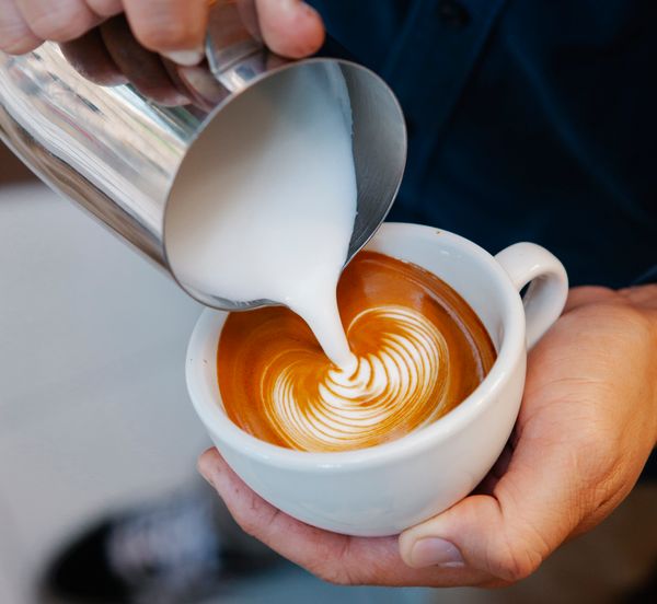 Barista preparando café con arte latte