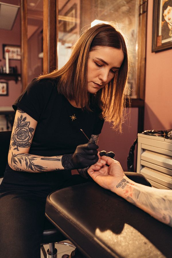 Tatuador trabajando un diseño con la máquina