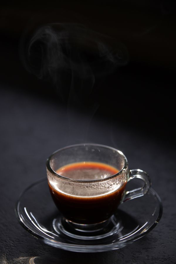 Taza de cafecito negro humeante